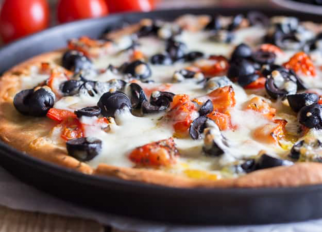 Pizza with olives in the pan.